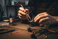 Person working on a small electronic device with tools and components on a table.