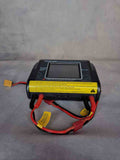 Battery charger with red and black cables on a gray surface